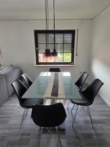 a dining room with a glass table and chairs at Vacation home Porta Westfalica - Vacation & Mechanic in Porta Westfalica