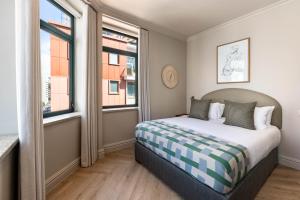 a bedroom with a bed and two windows at Charles Hope Boutique Hometel in Cape Town