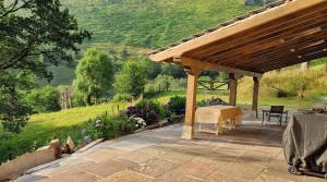 a wooden pergola with a table on a patio at Casa Rural Angostina in Carcabal