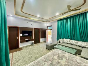 a living room with green curtains and a couch at harvest haven in Alwar +46 photos