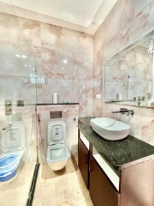 a pink bathroom with a toilet and a sink at harvest haven in Alwar