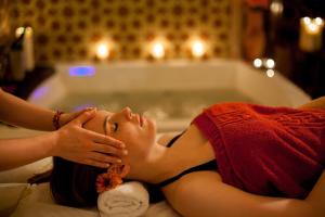 a woman laying in a bath tub with her eyes closed at Le Marrakech Boutique Hotel in Kleinblittersdorf