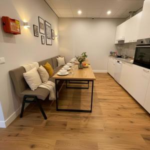 a living room with a table and a kitchen at Renovated Suite With Kitchen Access And Bathroom in Raamsdonksveer