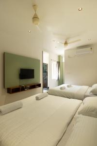 コインバトールにあるSri Varee Residency- Near to KMCH hospital & Coimbatore Airportのベッド2台と薄型テレビ付きのベッドルーム
