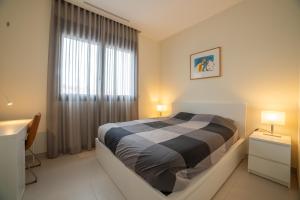 une chambre avec un lit et une grande fenêtre dans l'établissement Janmarsol, à Vinaròs