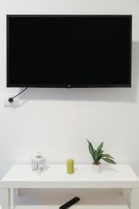 a flat screen tv sitting on top of a white table at Suite by Hawkins Exterior 1B in Algeciras