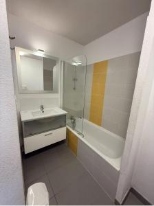 ein Badezimmer mit Waschbecken, Badewanne und Dusche in der Unterkunft T3 & tous conforts & piscine & sauna & plage in Argelès-sur-Mer