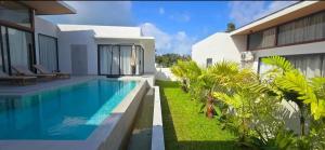 a villa with a swimming pool next to a house at Samui Luxury villas -By Samui Rental Villas in Nathon Bay