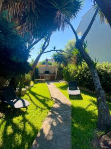 two chairs sitting in the grass with palm trees at TERRA DI MARE LOC. TURISTICA in Vignacastrisi