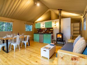 a living room with a table and a stove at AfriCamps Klein Karoo in Oudtshoorn