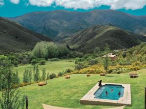 a person standing in a pool in a field with mountains at AfriCamps at Pat Busch in Robertson
