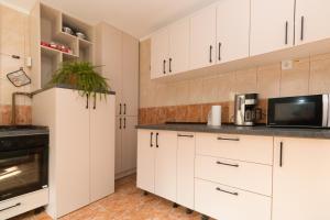 a kitchen with white cabinets and a microwave at Amber`s Vila in Buşteni