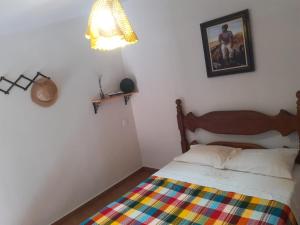 a bedroom with a bed with a colorful blanket at Serra da Capela in São José da Barra