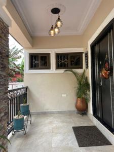 a house with a porch with a potted plant at UniGold Villa in Cape Coast