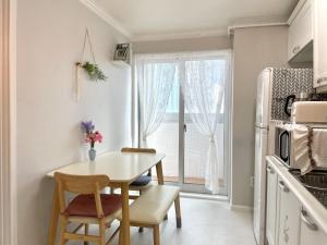 a kitchen with a table and chairs and a window at Aurora Stay in Pongsan-dong