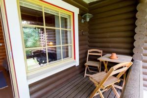 eine Veranda mit einem Tisch, Stühlen und einem Fenster in der Unterkunft Koli Iso-Ryläys in Kolinkylä