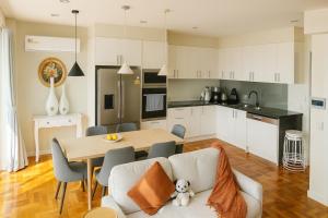 a kitchen and living room with a table and chairs at Stylish 4BR Easy CBD Access Walk to Train & Shops in Melbourne
