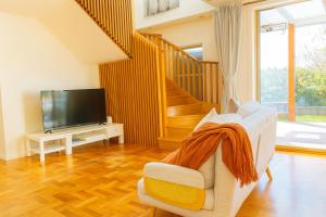 a living room with a couch and a television at Stylish 4BR Easy CBD Access Walk to Train & Shops in Melbourne