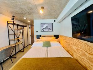 a room with two beds and a large screen at Peaky Riders Self Check-in Hotel in Zermatt