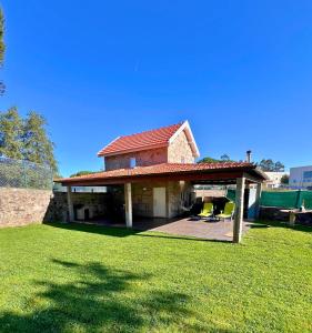 a house with a red roof on a grass field at Lourença Stays - Quinta Lourenca in Vilar