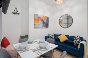 a living room with a blue couch and a table at Spacious 4 bed - 4 en-suites - Parking - Discounts in Doncaster +39 photos