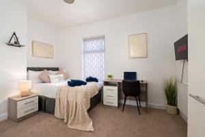 a bedroom with a bed and a desk with a computer at Spacious 4 bed - 4 en-suites - Parking - Discounts in Doncaster