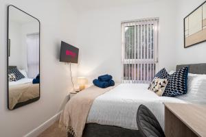 a bedroom with a bed with a mirror and a window at Spacious 4 bed - 4 en-suites - Parking - Discounts in Doncaster