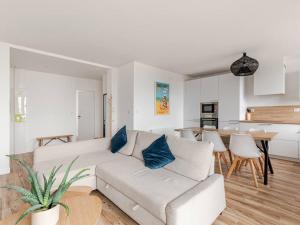 a living room with a white couch and a table at Appartement face mer à Malo avec parking privé in Dunkerque