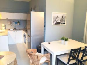 a kitchen with a white table and a refrigerator at Apartment in Ghiffa with Lake Maggiore Views in Ghiffa +18 photos