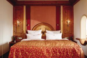 a bedroom with a large bed with a wooden headboard at Hotel Dollenberg in Bad Peterstal-Griesbach