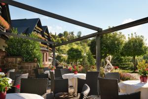 a patio at a restaurant with tables and chairs at Hotel Dollenberg in Bad Peterstal-Griesbach