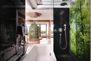 a bathroom with a bath tub with a shower at Hotel Dollenberg in Bad Peterstal-Griesbach