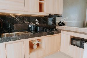 Una cocina con gabinetes de madera y encimera. en Slokayana Villas, en Uluwatu