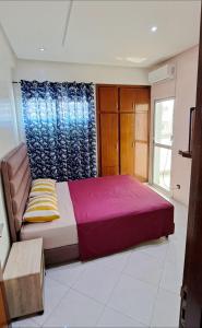 a bedroom with a large bed and a window at Appartement Centre Ville - ATLAS 46 in Fès