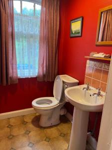 a red bathroom with a toilet and a sink at The Gardener's House in Covington +20 photos
