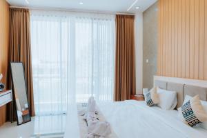 Un dormitorio con una cama blanca con una ventana grande. en Slokayana Villas, en Uluwatu