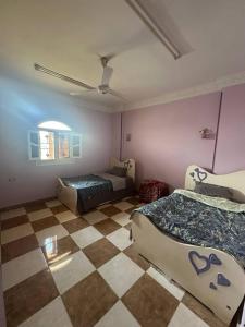 a bedroom with two beds and a checkered floor at Luna Nile in Aswan +18 photos