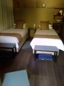 a room with two beds and a table in it at Mongwe Safari Camp 