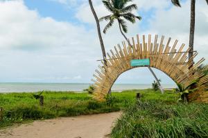 a wooden arch on a dirt road near the beach at Apto c Churrasqueira e Piscina a 100m da Praia in São Bento