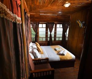 a bedroom with a bed in a room with curtains at spice garden Resorts munnar in Anachal