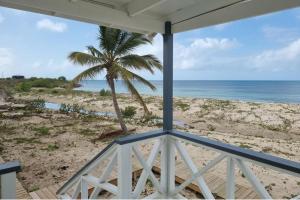 a view of the beach from the porch of a house at Charming 1-Bed Cottage in Codrington in Dulcina +10 photos