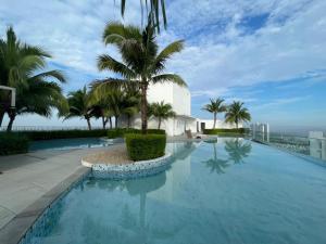a swimming pool with palm trees and a building at Eclipse Residence in Cyberjaya