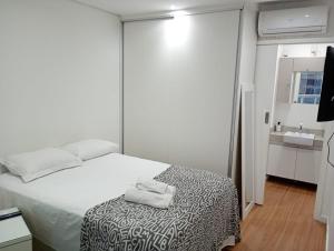 a bedroom with a bed with a towel on it at Estanconfor Santos com Vista Mar varanda e garagem in Campo Grande +24 photos