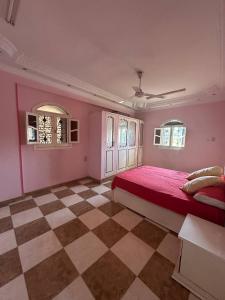 1 dormitorio con cama roja y suelo a cuadros en Luna Nile, en Asuán