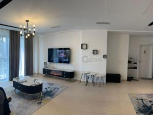 Una sala de estar con un televisor de pantalla plana en la pared. en SIKI F4 furnished residence for rent, en Dakar