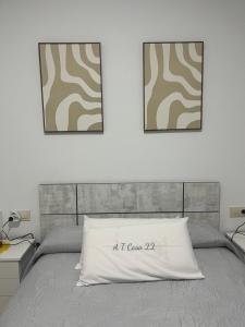 a bed with two pictures on the wall at Casa 22 in Plasencia +11 photos