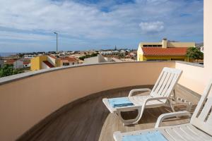 a pair of chairs sitting on a balcony at Casa Vista Azul With Pool in Porto Santo in Porto Santo