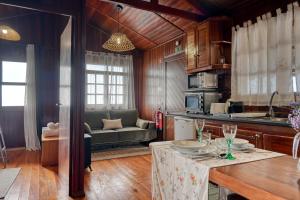 a kitchen and living room with a table and a couch at Chalet do Relógio d'Água, a Home in Madeira in Relógio do Poiso