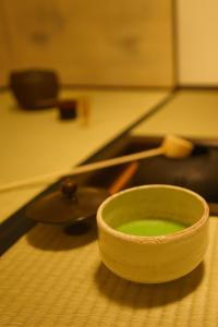 Un recipiente con líquido verde sobre una mesa. en Ryokan Tori, en Kioto