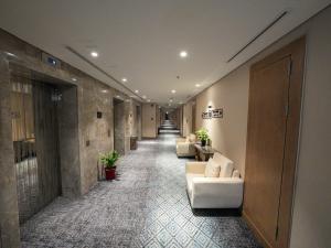 a hallway with white couches in a building at Casa Diora Hotel Al Rawdah in Jeddah